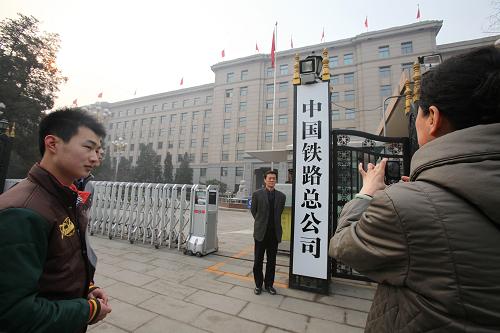 3月17日,一名男子在中国铁路总公司门牌前留影。当日,“中国人民共和国铁道部”的门牌被换为“中国铁路总公司”门牌,不少群众在门牌前拍照留念。新华社发