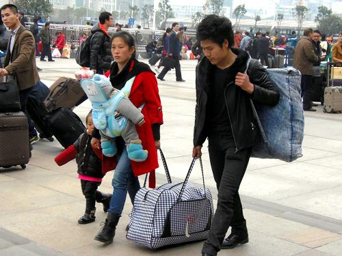2月25日,旅客带着孩子走在汉口火车站广场。当日,湖北省武汉市汉口火车站内的乘客比前几天增加了许多,大批务工人员、学生、游客等客流叠加,车站迎来返程客流高峰。新华社发(李长林 摄)